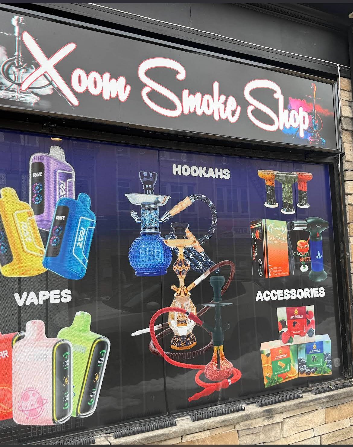 Storefront of Xoom Smoke Shop displaying vapes, hookahs, and smoking accessories in window